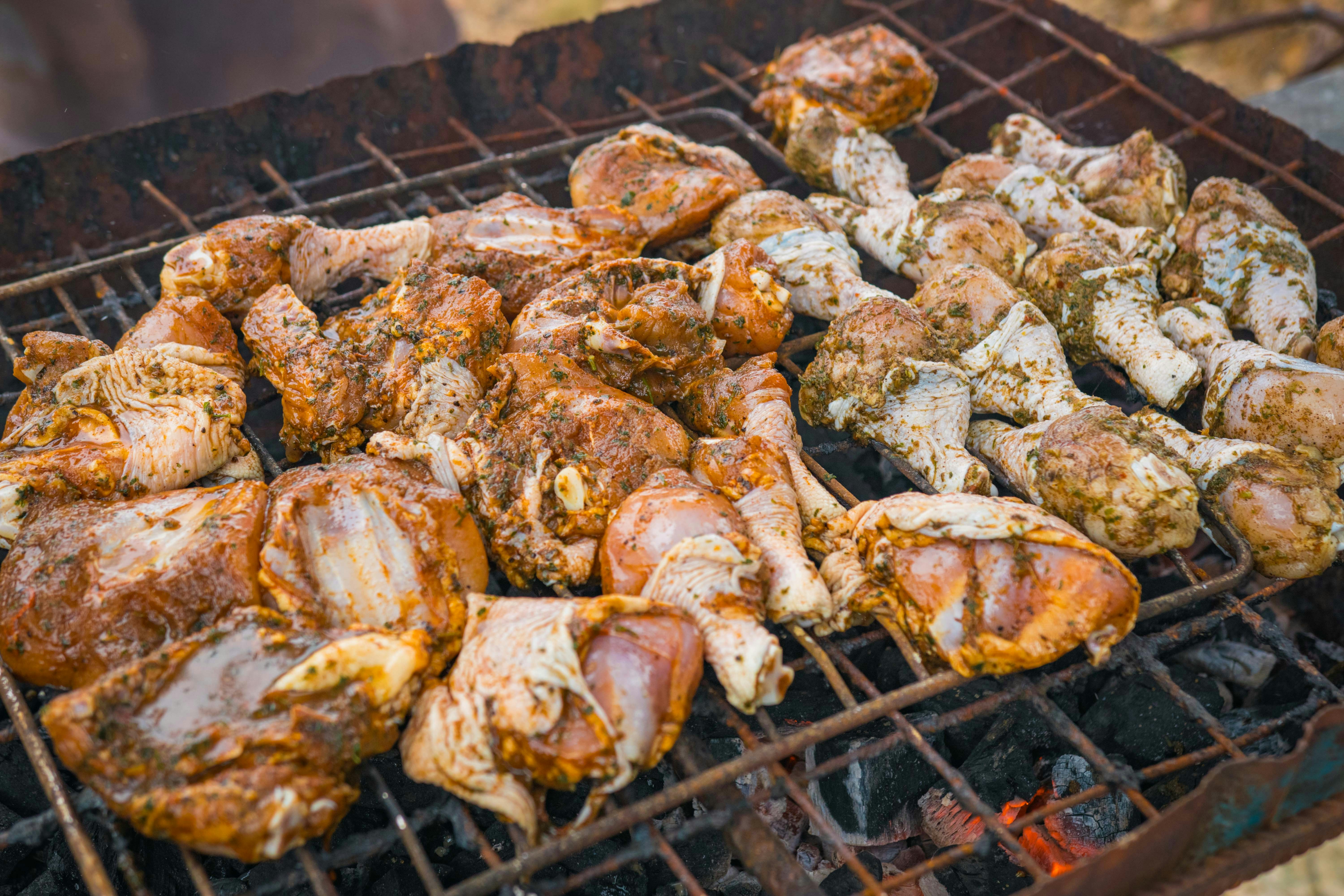 Marinated chicken legs on a charcoal grill with smoke